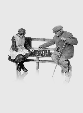 altes Paar spielt Schach auf Bank